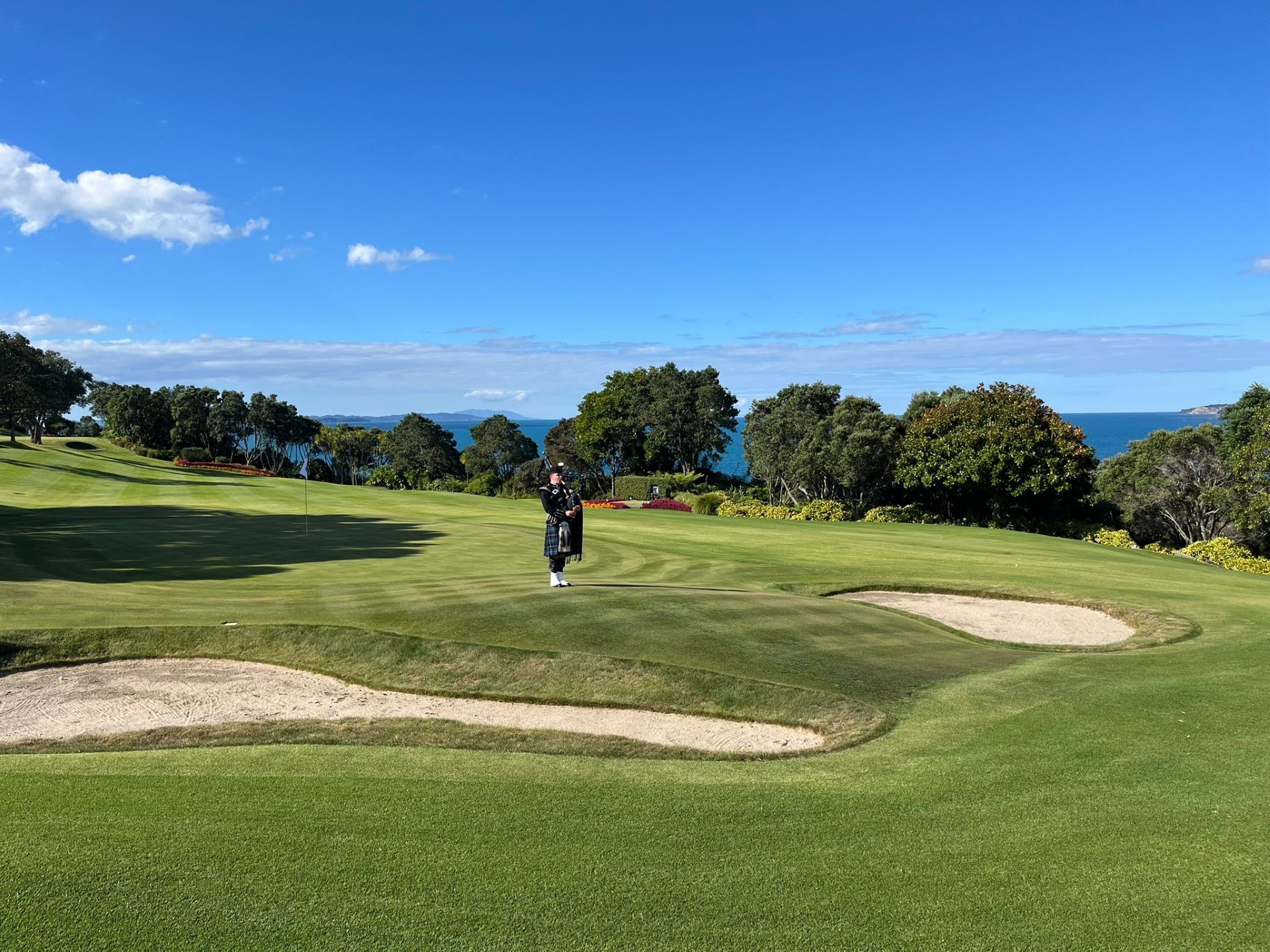 Piper performing on a golf course overlooking the sea