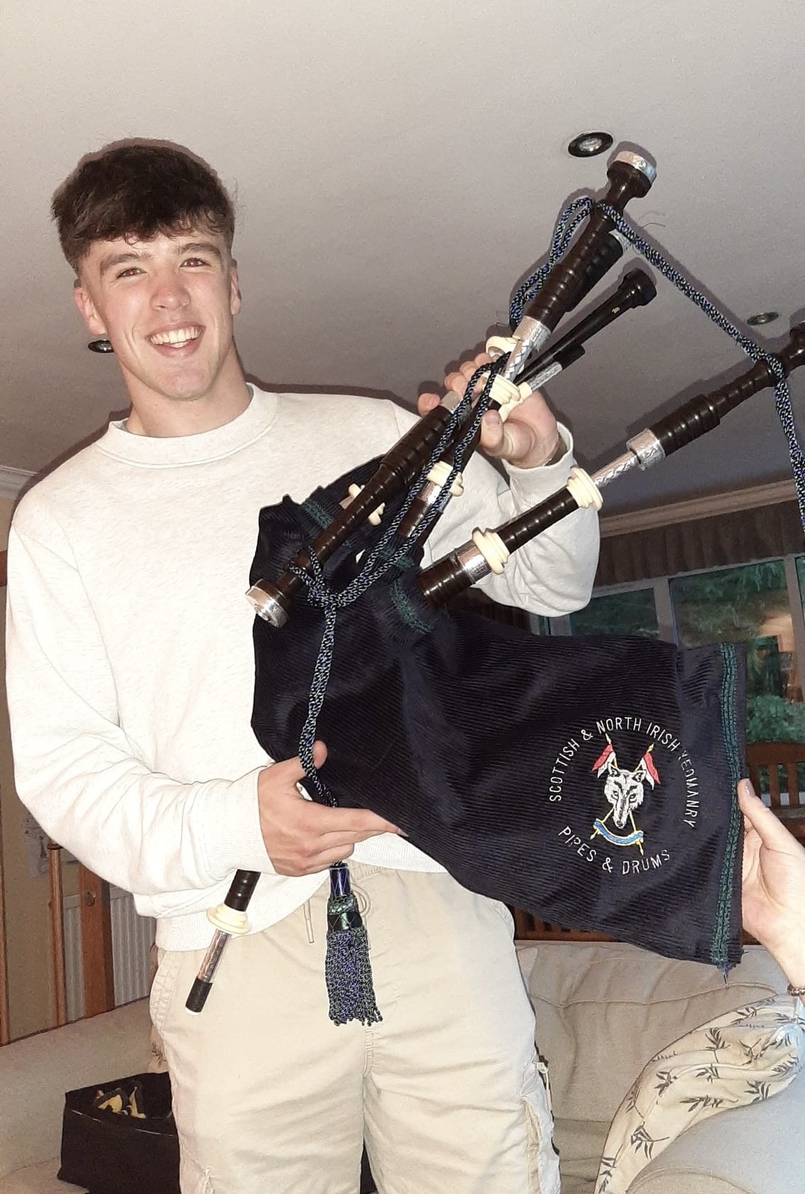 Felix Walker holding pipes with Scottish and North Irish Yeomanry bag